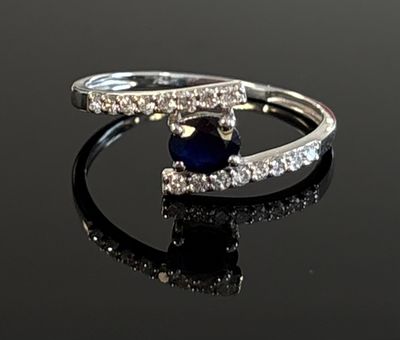an image of a diamond and sapphire ring on a black surface