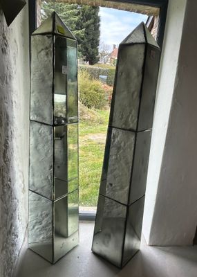 two mirrors sitting on a window sill next to each other