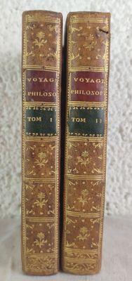 two old books sitting on top of a table next to each other