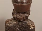 a statue of a man with a hat on top of a rock