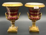 pair of red and gold vases sitting on top of a table