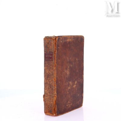 an old book that is sitting on a white surface