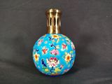 une image représentant un vase bleu orné de fleurs