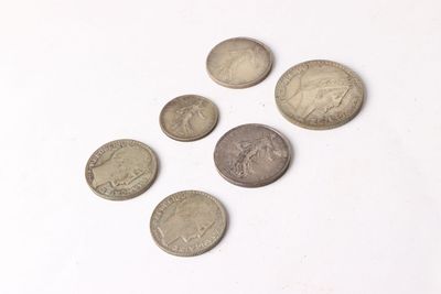 several coins are arranged on a white surface with a white background