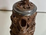 a brown vase with a bear on it on a table