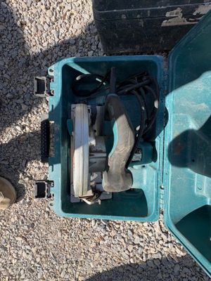 une mallette bleue posée par terre, contenant un outil