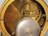 a gold clock with a silver ball in the middle of it