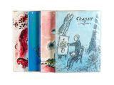 trois cahiers sur lesquels figurent des dessins, posés sur une surface blanche