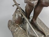 bronze statue of a man with a sword and a helmet