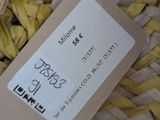 a woven basket with a tag on it and a ball of yarn