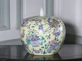 un vase posé sur une table, sur lequel se trouve un autre vase