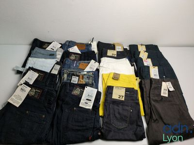 Plusieurs paires de jeans pour hommes sont alignées sur une table