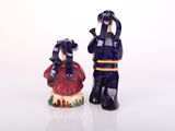 two figurines of a man and a woman standing next to each other