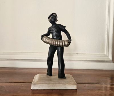 une statue représentant un homme tenant un hula-hoop sur un plancher en bois