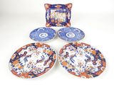 three plates and a picture frame sitting on top of a table