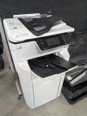une imprimante blanche posée sur une imprimante noir et blanc