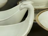 a lot of white and gold dishes on a table