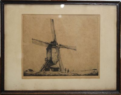 une vieille photo d'un moulin à vent, encadrée, posée sur une table