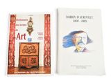 two books on a white surface with a drawing of a man