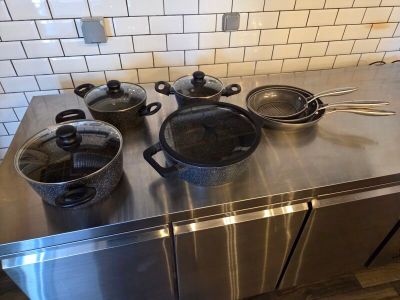 pots and pans sit on a stainless steel counter in a kitchen