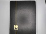 an open black book sitting on top of a white table