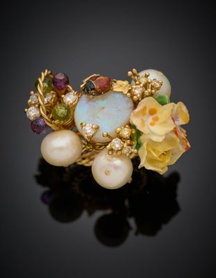 un gros plan d'une bague ornée de perles et de fleurs sur un fond noir