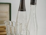 a glass bottle and a glass cup sitting on a table