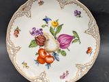 a plate with flowers and fruit on it on a table