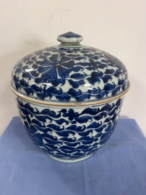 an image of a blue and white bowl with a lid on a blue cloth