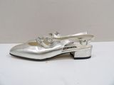 silver shoes with buckles on the toes on a white surface