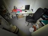 un bureau avec un ordinateur et une chaise dans une pièce
