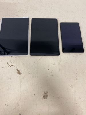 three cell phones sitting on top of a table next to each other