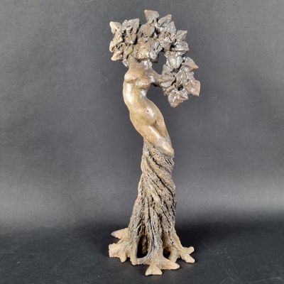 une statue représentant une femme tenant un bouquet de fleurs à la main