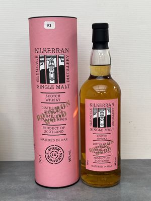 une photo d'une bouteille de whisky posée à côté d'une boîte rose