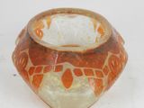 a small glass vase with an orange design on it