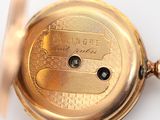 a close up of a gold pocket watch on a white surface