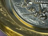 a gold plate with a picture of a soldier on it