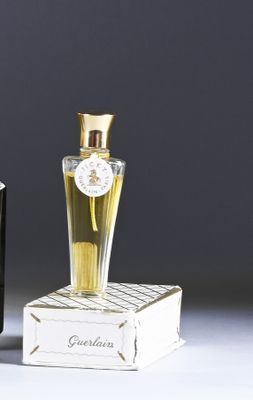 two bottles of perfume sitting next to each other on a table