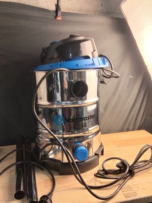 un aspirateur argenté et bleu posé sur une table en bois