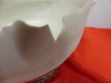a white vase with a red cloth on the table