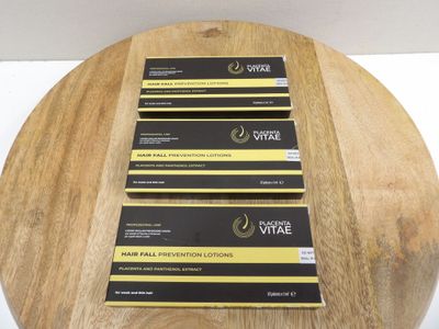 three boxes of hair removal lotion sitting on top of a wooden table