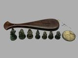 une cuillère en bois avec un manche en bois, posée à côté d'un groupe de petites figurines