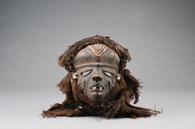 une image représentant un masque en bois avec un grand visage et de longs cheveux