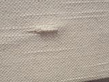 a close up of a piece of white cloth with a small hole in it