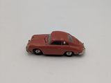a red toy car that is on a white surface