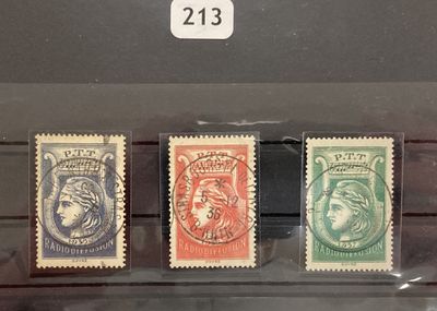trois timbres de couleurs différentes exposés dans une vitrine