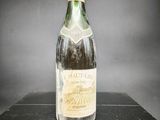 une vieille bouteille de vin posée sur une table noire