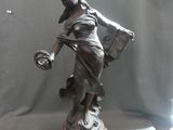 a statue of a woman holding a basket and a bag