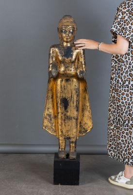 une femme qui se tient à côté d'une statue
