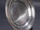 a silver plate sitting on a stand on a table